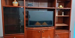 a tv sitting on a wooden entertainment center with a shelf at Casa com banheira para até 12 pessoas prox USP-HC fácil acesso para Arena EUROBIKE com Wi-Fi in Ribeirão Preto
