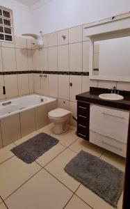 a bathroom with a sink and a toilet and a bath tub at Casa com banheira para até 12 pessoas prox USP-HC fácil acesso para Arena EUROBIKE com Wi-Fi in Ribeirão Preto