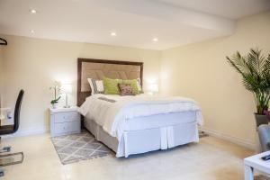 a bedroom with a large bed with green pillows at Nature Oasis Mar Suite in Dundas