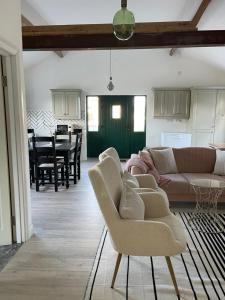 uma sala de estar com um sofá, cadeiras e uma mesa em Cosy apartment with fire stove em Athlone