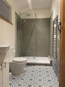 une salle de bain avec une baignoire, des toilettes et une douche dans l'établissement Tulip Cottage, à Wisborough Green