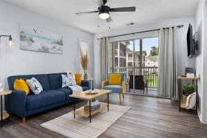 ein Wohnzimmer mit einem blauen Sofa und einem Deckenventilator in der Unterkunft Fully equipped 2BR 2BA with King Bed in heart of MB in Myrtle Beach