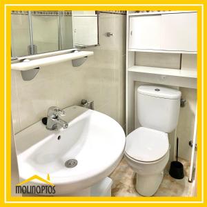 La salle de bains est pourvue d'un lavabo blanc et de toilettes. dans l'établissement Estudio 30 Frente al Mar, à Benidorm