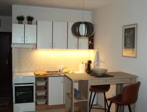 諾維薩德的住宿－Downtown Apartment，厨房配有白色橱柜和木桌