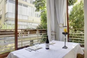 a table with a bottle of wine and glasses on a balcony at Sunset TLV Apartment - Dizengoff 142 in Tel Aviv