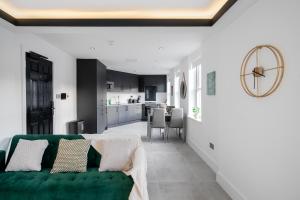 een woonkamer met een groene bank en een keuken bij Aryas Apartments Newbury in Newbury