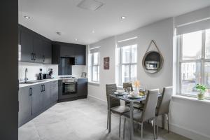 a kitchen and dining room with a table and chairs at Aryas Apartments Newbury in Newbury