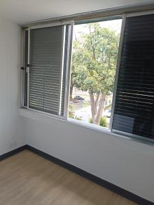 an empty room with two large windows with blinds at Alojamento Central - Funchal in Funchal