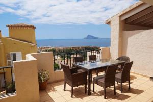 a table and chairs on a balcony with a view of the ocean at Agradable adosado con maravillosas vistas in Calpe
