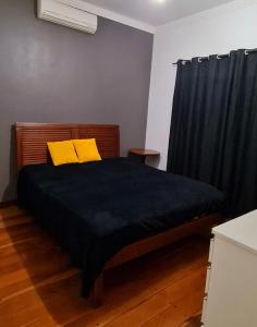 um quarto com uma cama com duas almofadas amarelas em Casa com banheira para até 12 pessoas prox USP-HC fácil acesso para Arena EUROBIKE com Wi-Fi em Ribeirão Preto