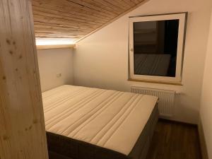 a bed in a small room with a mirror at Le chalet du kanal in Winseler