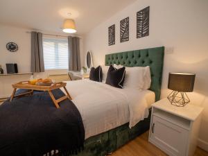 a bedroom with a large bed with a green headboard at Modern & Central - KING Bed, Super FAST Wi-Fi in Cambridge