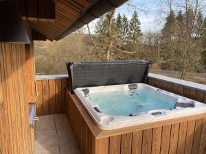 a jacuzzi tub sitting on a deck at Le chalet du kanal in Winseler