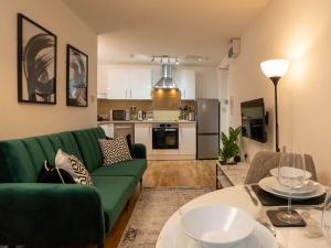 een woonkamer met een groene bank en een tafel bij Modern & Central - KING Bed, Super FAST Wi-Fi in Cambridge