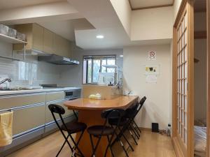 ビーチ徒歩１分のプライベート空間、民宿やまぐち في Susami: مطبخ مع طاولة وكراسي خشبية
