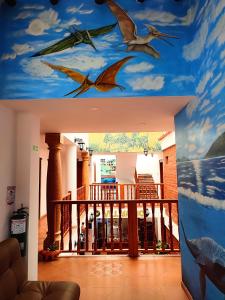 un pasillo con aves pintadas en el techo en Hotel Villasaurio, en Sáchica