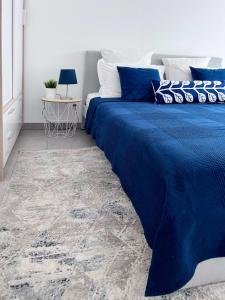 1 dormitorio con cama azul y edredón azul en Superbe appartement neuf entre mer et pins Wifi en Argelès-sur-Mer