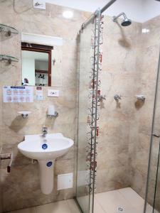 a bathroom with a sink and a glass shower at Hotel Villasaurio in Sáchica