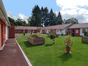 una fila de casas con plantas en un patio en Béguinage le Val d'Or en Paray-le-Monial