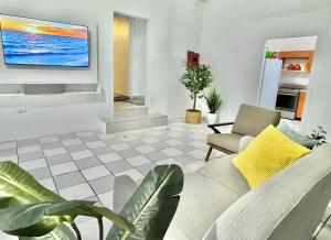 sala de estar con sofá y TV en la pared en Oasis Inn, en San Juan