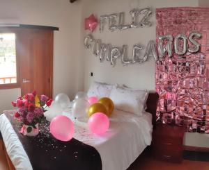 a room with a bed with balloons and a happy birthday sign at HOTEL SPA Villasaurio in Sáchica