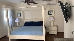 a bedroom with a canopy bed with blue pillows at Apartment in Cadaques Caribe in Bayahibe