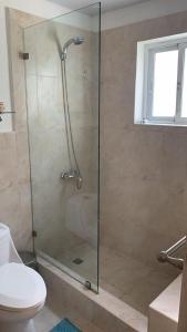 a bathroom with a glass shower with a toilet at Apartment in Cadaques Caribe in Bayahibe