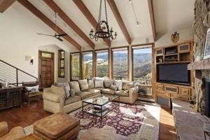 a living room with a couch and a tv at Top of Lemond Home in Snowmass Village
