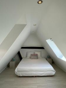 ein Schlafzimmer mit einem weißen Bett im Dachgeschoss in der Unterkunft La Mariana - Old Town Cosy Apartments in Colmar