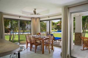 ein Esszimmer mit einem Tisch und Stühlen sowie Glasschiebetüren in der Unterkunft Golf Condo A1 F1: Nice view and access to the largest pool in Hacienda Iguana! in Rivas
