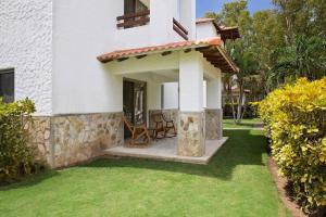 una casa con patio y patio de césped en Golf Condo A1 F1: Nice view and access to the largest pool in Hacienda Iguana!, en Rivas