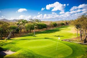 uma imagem de um campo de golfe com um verde em Golf Condo A1 F1: Nice view and access to the largest pool in Hacienda Iguana! em Rivas