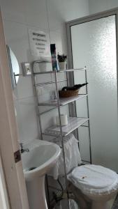 een badkamer met een wit toilet en een wastafel bij Cabañas Aliwen in Ñilque