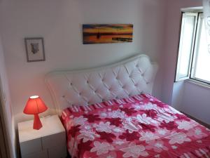 una camera con letto bianco e lampada rossa di Appartamento Perla Dello Ionio a Gallipoli