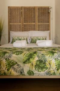 una camera da letto con un letto con una coperta di palma di Suites Bambu a Setúbal