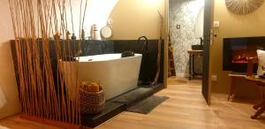 baño con bañera y chimenea en Charmante suite romantique avec cave à vin, en Cournonsec