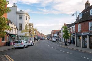 eine Stadtstraße mit auf der Straße geparkt in der Unterkunft Aryas Apartments Newbury in Newbury