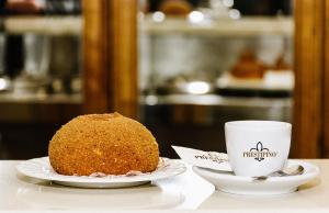 una tarta y una taza de café sobre una mesa en Zahara en Catania