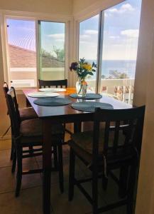 uma mesa de jantar com cadeiras e um vaso de flores em Blue Whale Inn San Clemente Retreat Unit E em San Clemente