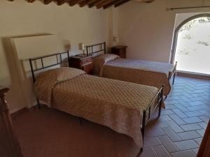 two beds in a room with a window at Villa Querciolaia nel chianti in Pieve a Presciano