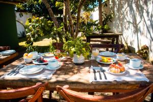 a wooden table with plates of food on it at Pousada Tamikuã in Caraíva