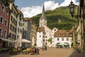 a town with a church with a clock tower at La Suite in Chur