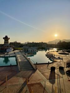 a sunset over a marina with boats in the water at Fully Equipped Apartments Pool & Mountains View in Porto Sharm Resort in Sharm El Sheikh