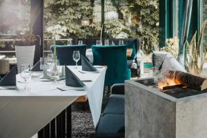 un restaurant avec une table et un foyer extérieur dans l'établissement Parkhotel Waldschlösschen, à Annaberg-Buchholz