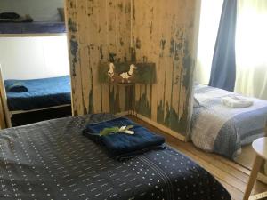 1 dormitorio con 2 camas individuales y pared de madera en Corella Creek Country Farm Stay, en Nelia