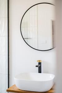 a bathroom with a white sink and a mirror at Your home on Smith St Collingwood (With Parking) in Melbourne