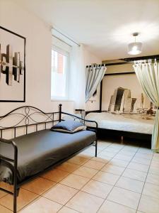 a bedroom with two beds and a mirror at Charmant studio proximité centre-ville et gare in Châlons-en-Champagne
