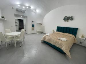 a bedroom with a bed and a table and chairs at B&B suite anfiteatro Pozzuoli in Pozzuoli