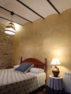 ein Schlafzimmer mit einem Bett und einem Tisch mit einer Lampe in der Unterkunft CASABRAS RURAL in Claravalls