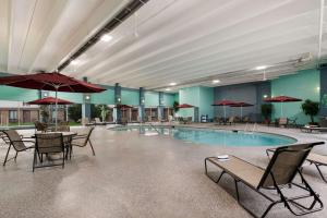 una piscina con mesas de sillas y sombrillas en un edificio en Best Western Holiday Lodge, en Clear Lake